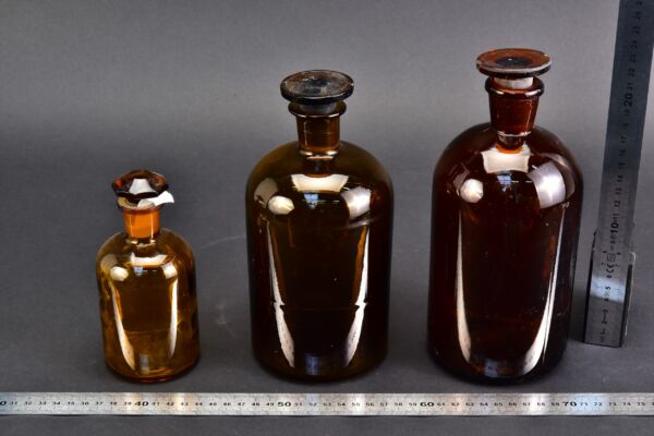 Three assorted amber reagent bottles with ground-glass stoppers Three assorted amber reagent bottles with ground-glass stoppers