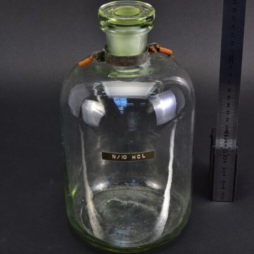 Clear reagent bottle with glass stopper, spring-equipped metal collar and “N/10 HCL” label Clear reagent bottle with glass stopper, spring-equipped metal collar and “N/10 HCL” label